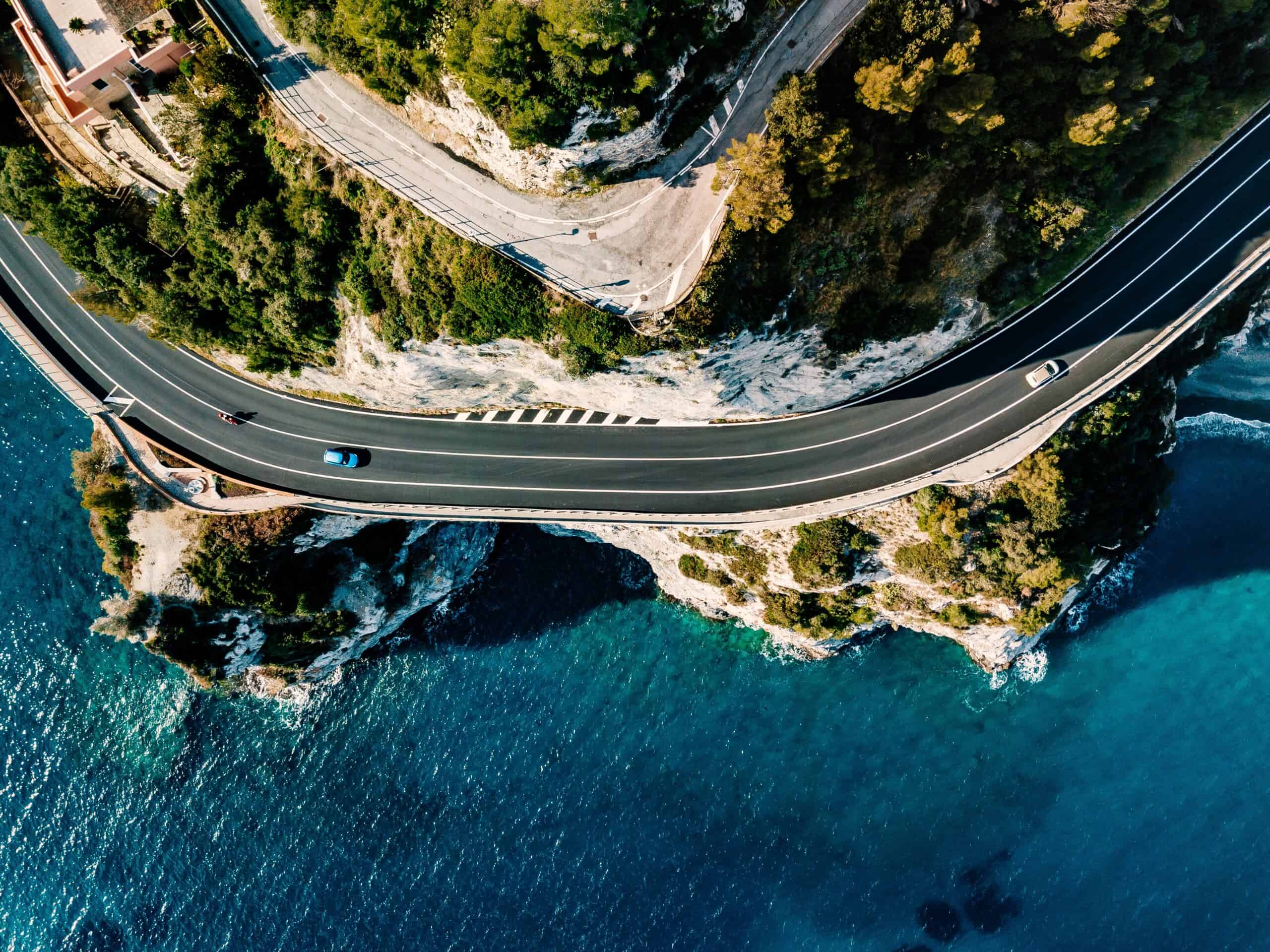 Aerial view of road going along the mountain and ocean or sea. Drone photography from above